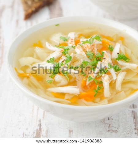 bowl of vegetable soup with chicken and parsley closeup