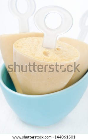 ice cream on a stick with Earl Grey tea in a bowl close-up vertical