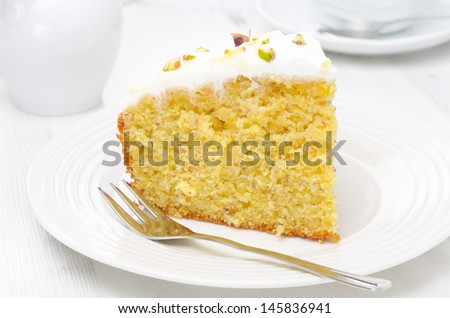 piece of orange cake decorated with Greek yogurt, honey and pistachios