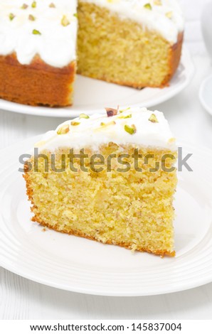 piece of orange cake with Greek yogurt, honey and pistachios, vertical