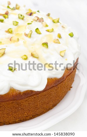 orange cake with Greek yogurt, honey and pistachios on a plate