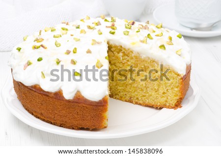 orange cake with Greek yogurt, honey and pistachios in a cut, close-up