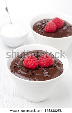 chocolate mousse with raspberries and whipped cream on a white background