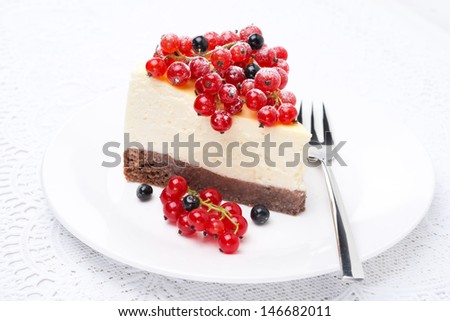 piece of cheesecake, decorated with red and black currants, close-up