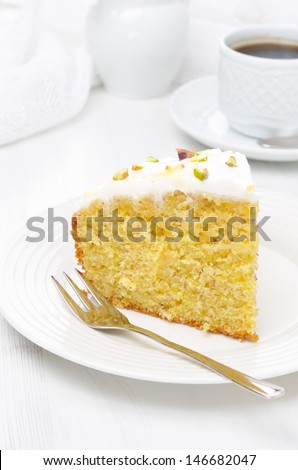 piece of orange cake decorated with Greek yogurt, honey and pistachios, vertical