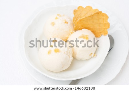Ginger ice cream with melted milk and thin waffles, top view close-up