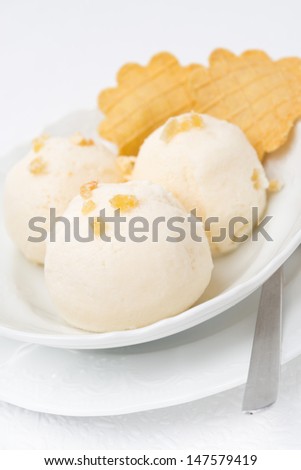 Ginger ice cream with melted milk, thin waffles close-up vertical