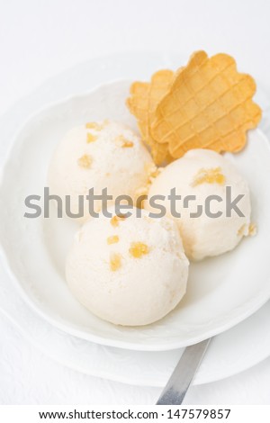 Ginger ice cream with melted milk and thin waffles, top view