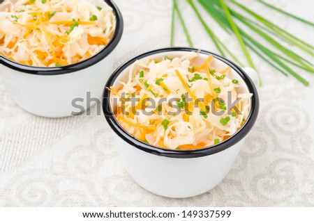 salad of pickled cabbage with carrots and green onions horizontal, top view close-up