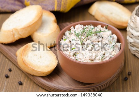 pate of smoked fish with sour cream and herbs on a wooden board