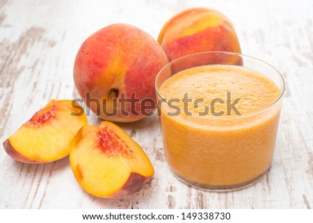fresh squeezed peach juice and fresh peaches on the white wooden table
