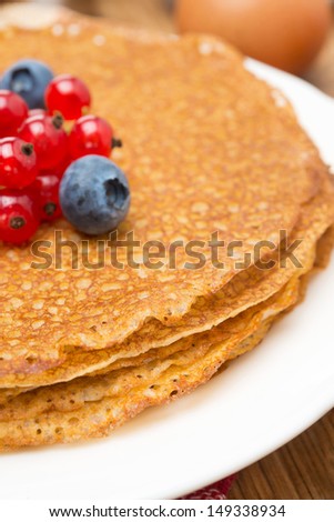 crepes with fresh berries close-up, selective focus, vertical