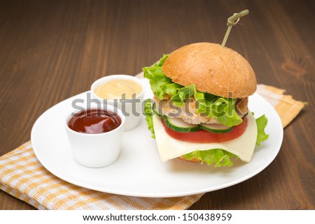 homemade burger with ketchup and mustard on the plate