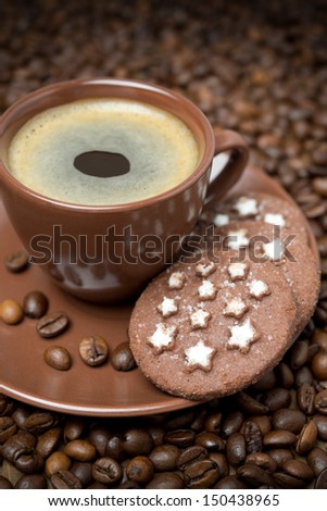 cup of black coffee and Christmas cookies on the coffee beans background, vertical