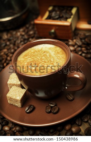 cup of black coffee with sugar on the background of coffee beans, vertical