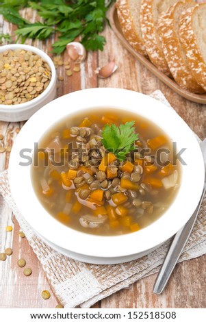 plate of vegetable soup with lentils on the table, vertical