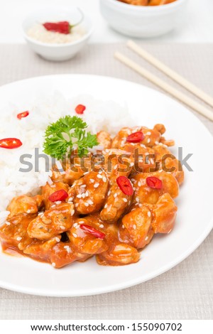 chicken fillet in tomato sauce with sesame seeds and rice, vertical