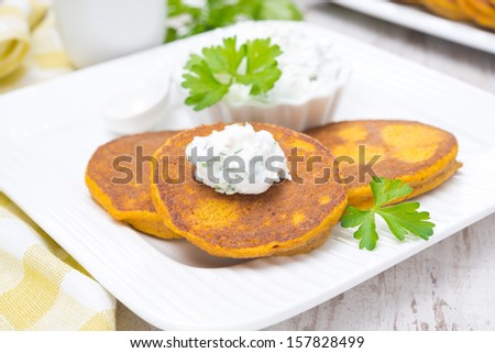 pumpkin pancakes with feta cheese sauce and greens, close-up