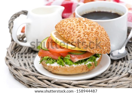 breakfast - burger with smoked salmon, vegetables and a cup of coffee, close-up