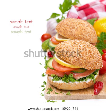 burgers with smoked salmon and vegetables on wooden board, isolated on white