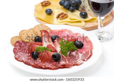 assorted deli meats, a plate of cheese and a glass of wine, isolated on white