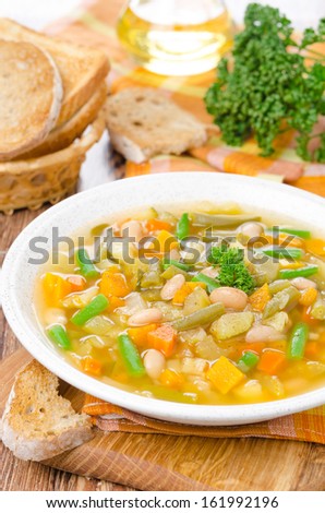 plate of vegetable minestrone with white beans and toast vertical