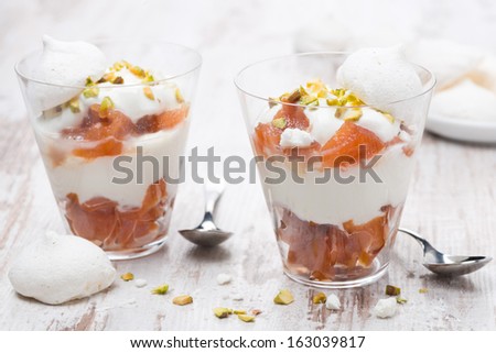 dessert with canned peaches, whipped cream and meringue in a glasses, horizontal