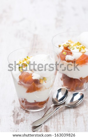 dessert with peaches, whipped cream and meringue on white wooden table