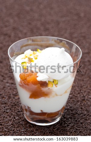 dessert with peaches, whipped cream, meringue and pistachios, vertical