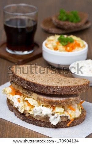 sandwich with coleslaw and baked meat, vertical