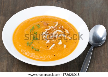 carrot soup with almonds and cress salad, close-up, horizontal
