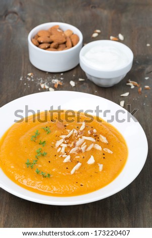 carrot soup with almonds and watercress, vertical, close-up