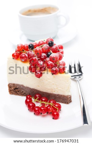piece of cheesecake with red and black currants and a cup of coffee, close-up