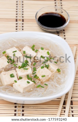 soup with rice noodles and marinated tofu, close-up, vertical