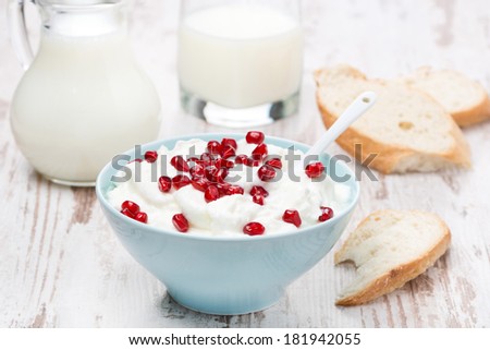 homemade yogurt with pomegranate, milk and bread on the wooden table