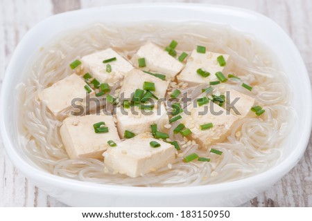 soup with rice noodles, tofu and green onions, close-up, horizontal