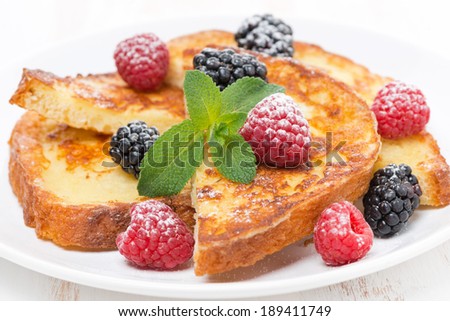 French toast with fresh berries, mint and powdered sugar, close-up