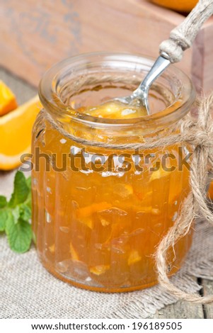 delicious orange marmalade in a glass jar, vertical, close-up