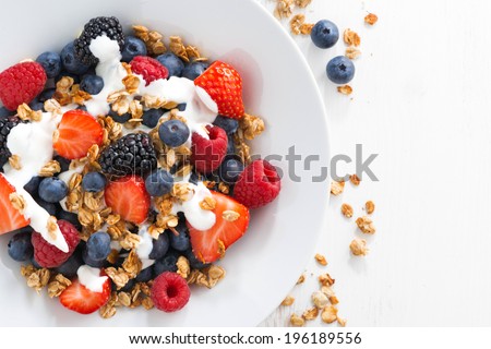 fresh berries, yogurt and homemade granola for breakfast, close-up, top view, horizontal