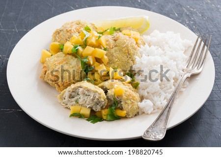 Thai fish cakes with mango salsa and white rice on a plate