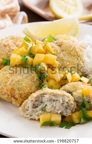 Thai fish cakes with mango salsa and rice, selective focus, close-up, vertical