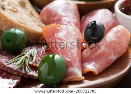 assorted Italian antipasti - deli meats, olives and ciabatta, close-up, horizontal