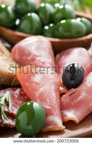 assorted Italian antipasti - deli meats, olives and ciabatta, selective focus, close-up