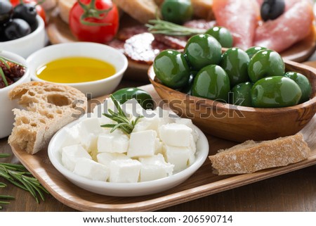 antipasti platter - fresh feta cheese, deli meats, olives and ciabatta, close-up
