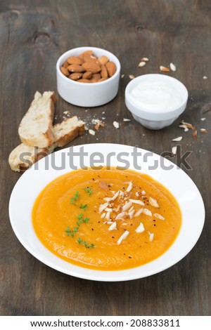 plate of carrot soup with almonds and watercress, close-up