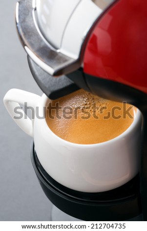 white cup of coffee in the coffee machine, vertical, close-up
