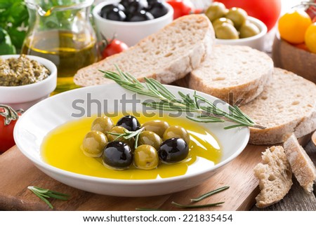 fresh olive oil in plate and Italian snacks, close-up