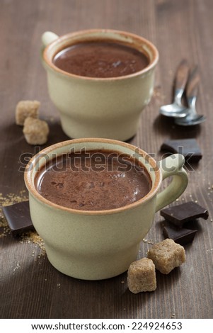 two cups of hot chocolate and sugar cubes, vertical