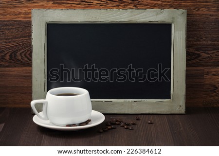 black writing board and a cup of coffee with steam, horizontal