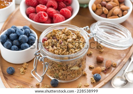 glass jar with homemade granola and berries, top view